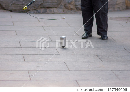 Man whipping spinning tops, traditional Chinese game Man whipping spinning tops, traditional Chinese game 137549006