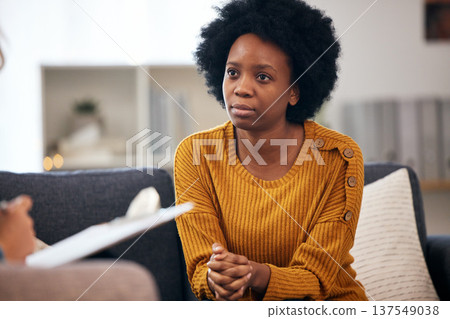 Woman, therapy patient and checklist in counseling, psychology evaluation and mental health support or helping. African client on sofa, life coach or professional therapist writing notes on clipboard Woman, therapy patient and checklist in counseling, psychology evaluation and mental health support or helping. African client on sofa, life coach or professional therapist writing notes on clipboard 137549038