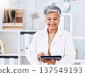 Tablet, doctor and smile of woman in clinic for online healthcare management, hospital software and research. Mature medical professional with digital technology for telehealth, data review and app 137549193