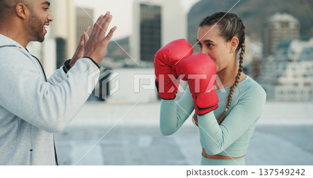 Boxing, coach and woman outdoor for training on rooftop in a city. Couple of friends, athlete and boxer gloves with personal trainer man for martial arts workout, exercise and fight for combat sports 137549242