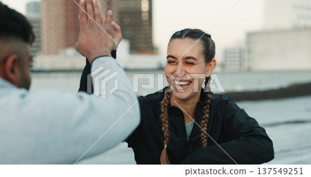 Happy couple, celebration or high five on rooftop for fitness exercise or workout together with pride or smile. Athletes, motivation or excited or man with woman, support or goal on building in city Happy couple, celebration or high five on rooftop for fitness exercise or workout together with pride or smile. Athletes, motivation or excited or man with woman, support or goal on building in city 137549251