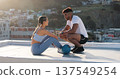 Fitness, couple and outdoor to talk and rest for exercise, workout or training together on a city rooftop. Happy man and woman on sports break with medicine ball, communication and coach in Cape Town 137549254