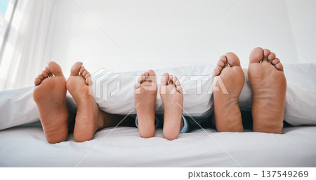 Sleeping, feet and family in a bed with love, relax and resting in comfort in their home together. Barefoot, care and child with mom, father and security in bedroom for sleep, bonding and weekend nap 137549269