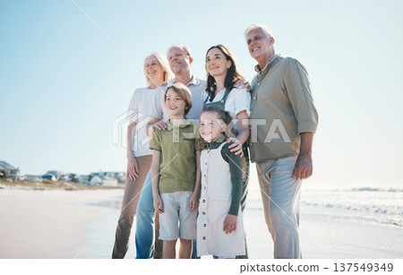 Grandparents, kids and big family with smile at beach, hug or bonding for love, sunshine or excited on vacation. Men, women and children by sea, waves or happy embrace for holiday for summer in Spain Grandparents, kids and big family with smile at beach, hug or bonding for love, sunshine or excited on vacation. Men, women and children by sea, waves or happy embrace for holiday for summer in Spain 137549349