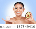 Woman, cream and avocado with natural beauty, vegan product and sustainable skincare on blue background. Portrait, smile and green fruit, lotion and eco friendly skincare with glow in a studio 137549410