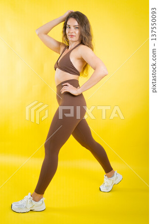 Confident woman posing in brown activewear Confident woman posing in brown activewear 137550093