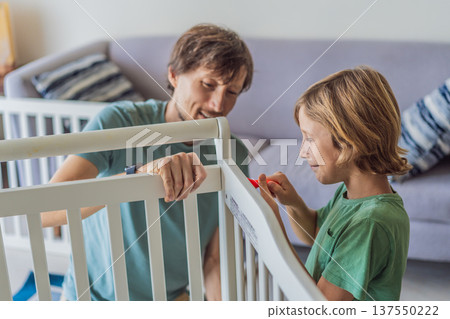 Father and older brother assembling a baby crib at home, preparing for a newborn arrival. Warm family moment full of care and anticipation. Parenthood, sibling bond and home preparation concept Father and older brother assembling a baby crib at home, preparing for a newborn arrival. Warm family moment full of care and anticipation. Parenthood, sibling bond and home preparation concept 137550222