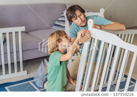 Father and older brother assembling a baby crib at home, preparing for a newborn arrival. Warm family moment full of care and anticipation. Parenthood, sibling bond and home preparation concept Father and older brother assembling a baby crib at home, preparing for a newborn arrival. Warm family moment full of care and anticipation. Parenthood, sibling bond and home preparation concept 137550226