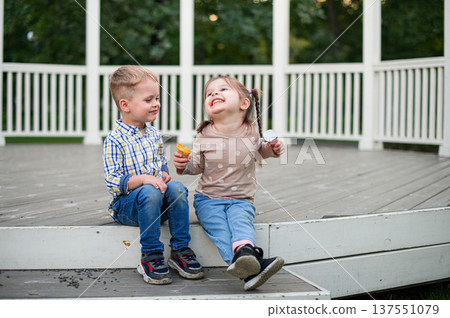 Children sitting and eating snacks in park gazebo Children sitting and eating snacks in park gazebo 137551079