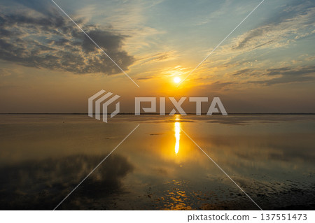 Golden sunset over the Tuzlivsky estuaries in Lebedivka, Ukraine, creating a peaceful and picturesque natural landscape. Golden sunset over the Tuzlivsky estuaries in Lebedivka, Ukraine, creating a peaceful and picturesque natural landscape. 137551473