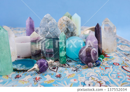 Healing crystals and pendulums arranged on patterned carpet Healing crystals and pendulums arranged on patterned carpet 137552034