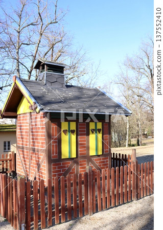 A fairytale half-timbered house with yellow shutters and hearts in the park A fairytale half-timbered house with yellow shutters and hearts in the park 137552410