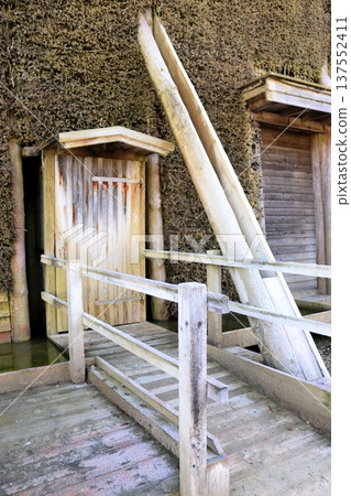 A wooden door and ramp against a wall of cooling tower branches A wooden door and ramp against a wall of cooling tower branches 137552411