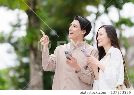 A couple searching for a destination on their smartphone 137553539