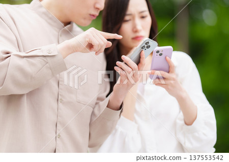 A couple searching for a destination on their smartphone A couple searching for a destination on their smartphone 137553542