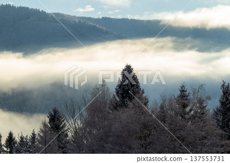 Sunrise makes a breakthrough in the mist between the mountains 137553731