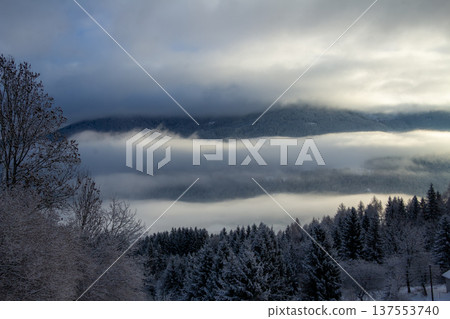 Sunrise makes a breakthrough in the mist between the mountains Sunrise makes a breakthrough in the mist between the mountains 137553740