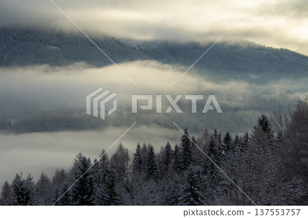Sunrise makes a breakthrough in the mist between the mountains Sunrise makes a breakthrough in the mist between the mountains 137553757