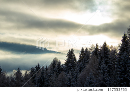 Sunrise makes a breakthrough in the mist between the mountains Sunrise makes a breakthrough in the mist between the mountains 137553763