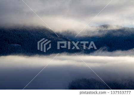 Sunrise makes a breakthrough in the mist between the mountains Sunrise makes a breakthrough in the mist between the mountains 137553777