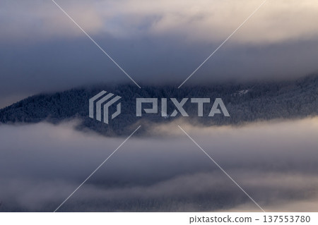 Sunrise makes a breakthrough in the mist between the mountains Sunrise makes a breakthrough in the mist between the mountains 137553780
