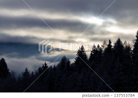 Sunrise makes a breakthrough in the mist between the mountains Sunrise makes a breakthrough in the mist between the mountains 137553784