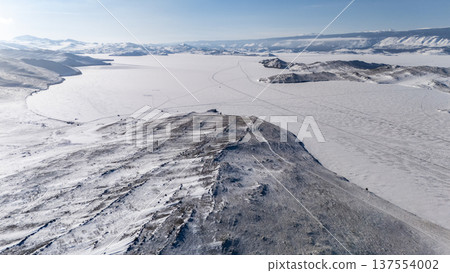 Aerial view of frozen lake Baikal in winter season, the surface of lake covered by snow. Aerial view of frozen lake Baikal in winter season, the surface of lake covered by snow. 137554002