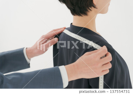 Tailor taking measurements 137554731