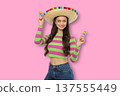 Cinco de Mayo, A young woman wears a sombrero and holds maracas 137555449