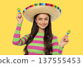 Cinco de Mayo, Young woman in sombrero smiles with maracas 137555453