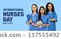 Three nurses in blue scrubs smile for Nurses Day 137555492