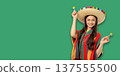 Cinco de Mayo, Woman in traditional outfit smiles with maracas 137555500