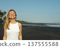 A woman smiles on a black sand beach in Bali 137555588