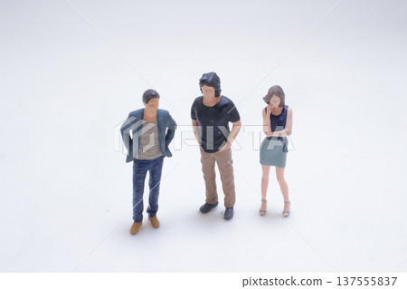 Three miniature figures standing together in studio scene 137555837