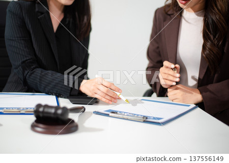 Business and lawyers discussing contract papers with brass scale on desk in office. Law, legal services, advice, justice and law Business and lawyers discussing contract papers with brass scale on desk in office. Law, legal services, advice, justice and law 137556149