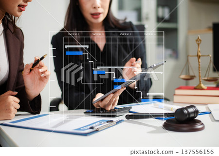 Business lawyers analyzing legal project timeline on tablet with gavel and documents, concept of corporate compliance, contract strategy, workflow management Business lawyers analyzing legal project timeline on tablet with gavel and documents, concept of corporate compliance, contract strategy, workflow management 137556156