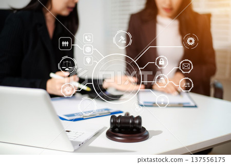 Asian women lawyers reviewing contract documents on tablet, discussing legal compliance, finance, cybersecurity and corporate business strategy 137556175