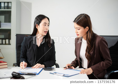 Business and lawyers discussing contract papers with brass scale on desk in office. Law, legal services, advice, justice and law Business and lawyers discussing contract papers with brass scale on desk in office. Law, legal services, advice, justice and law 137556176