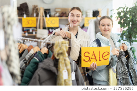 Woman on sale with her daughter in a clothing store Woman on sale with her daughter in a clothing store 137556295