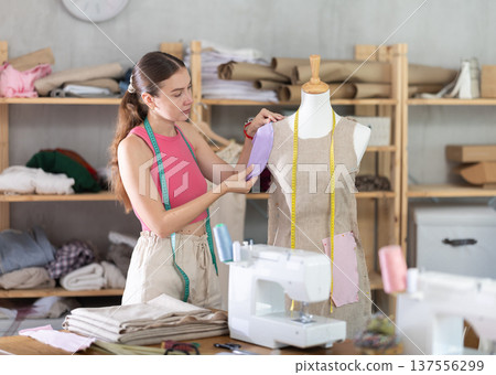 Tailor connects parts of dress on mannequin Tailor connects parts of dress on mannequin 137556299