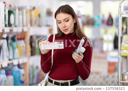 Woman choosing toothpaste in supermarket Woman choosing toothpaste in supermarket 137556321