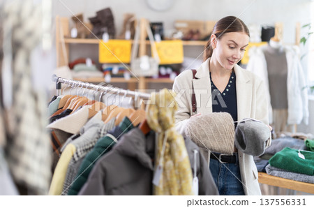 Adult woman choosing hat in clothing store 137556331