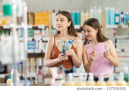 Woman and daughter choosing toothbrushes at the pharmacy Woman and daughter choosing toothbrushes at the pharmacy 137556332