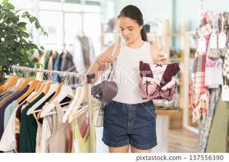 Young woman chooses underwear in clothing store Young woman chooses underwear in clothing store 137556390
