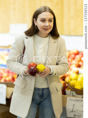 Young woman choosing apples in vegetable shop Young woman choosing apples in vegetable shop 137556523