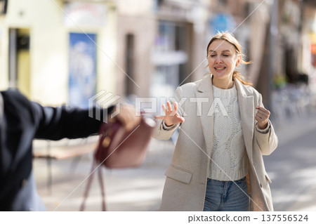 Male thief stealing woman bag on street Male thief stealing woman bag on street 137556524