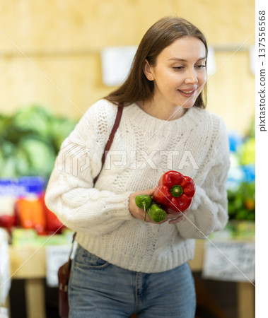 Girl shopping, examine vegetable in store and buy elect pepper 137556568