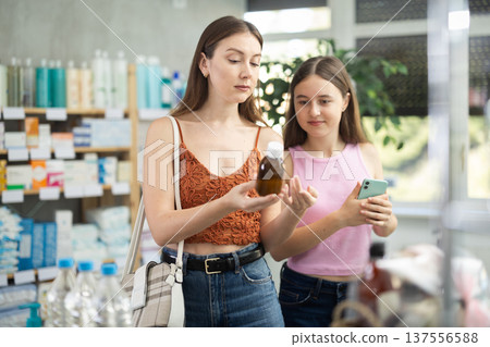 woman with a child chooses cough syrup woman with a child chooses cough syrup 137556588