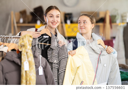 Woman and daughter choosing winter clothes in the store 137556601