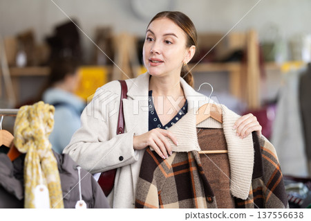 Young woman choosing a coat in a store Young woman choosing a coat in a store 137556638